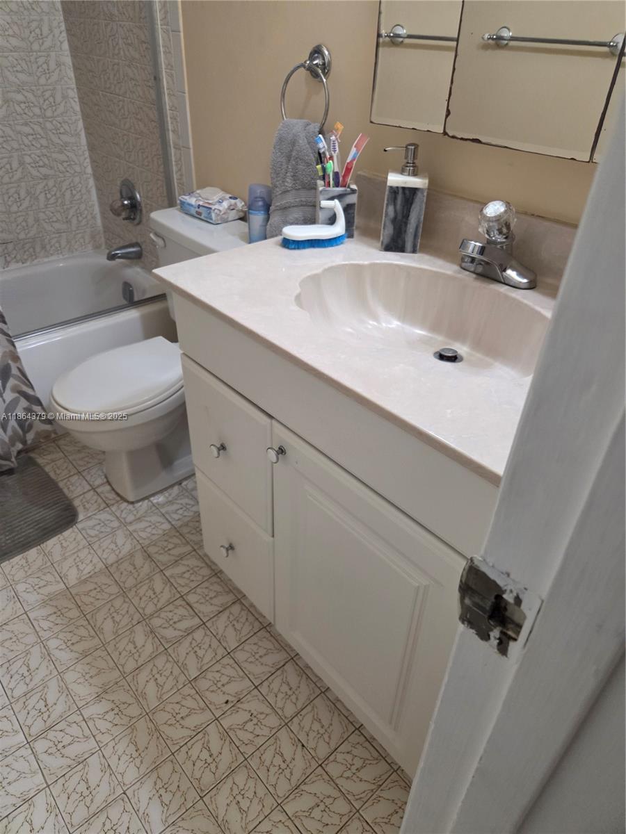 14165 Southwest 87th Street, Unit D103 Miami, FL 33183 - Photo 13 of 41 a bathroom with a sink and a toilet