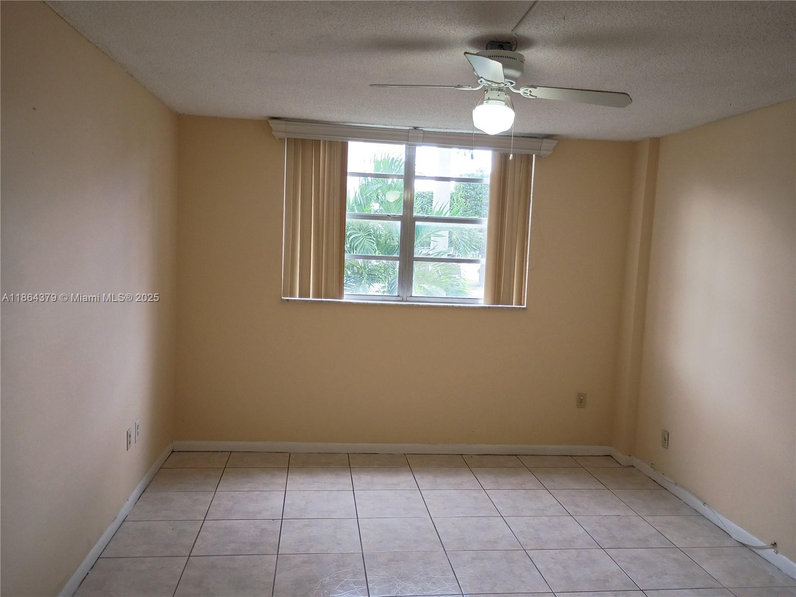 14165 Southwest 87th Street, Unit D103 Miami, FL 33183 - Photo 31 of 41 an empty room with windows and fan