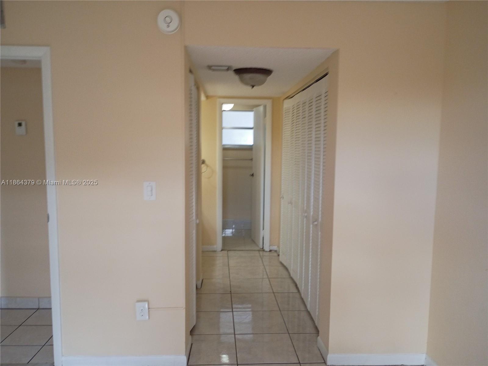 14165 Southwest 87th Street, Unit D103 Miami, FL 33183 - Photo 33 of 41 a view of a hallway with wooden floor and a bathroom