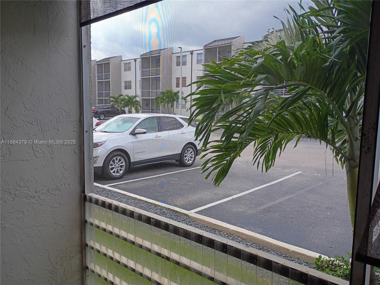 14165 Southwest 87th Street, Unit D103 Miami, FL 33183 - Photo 39 of 41 a car parked in front of a building