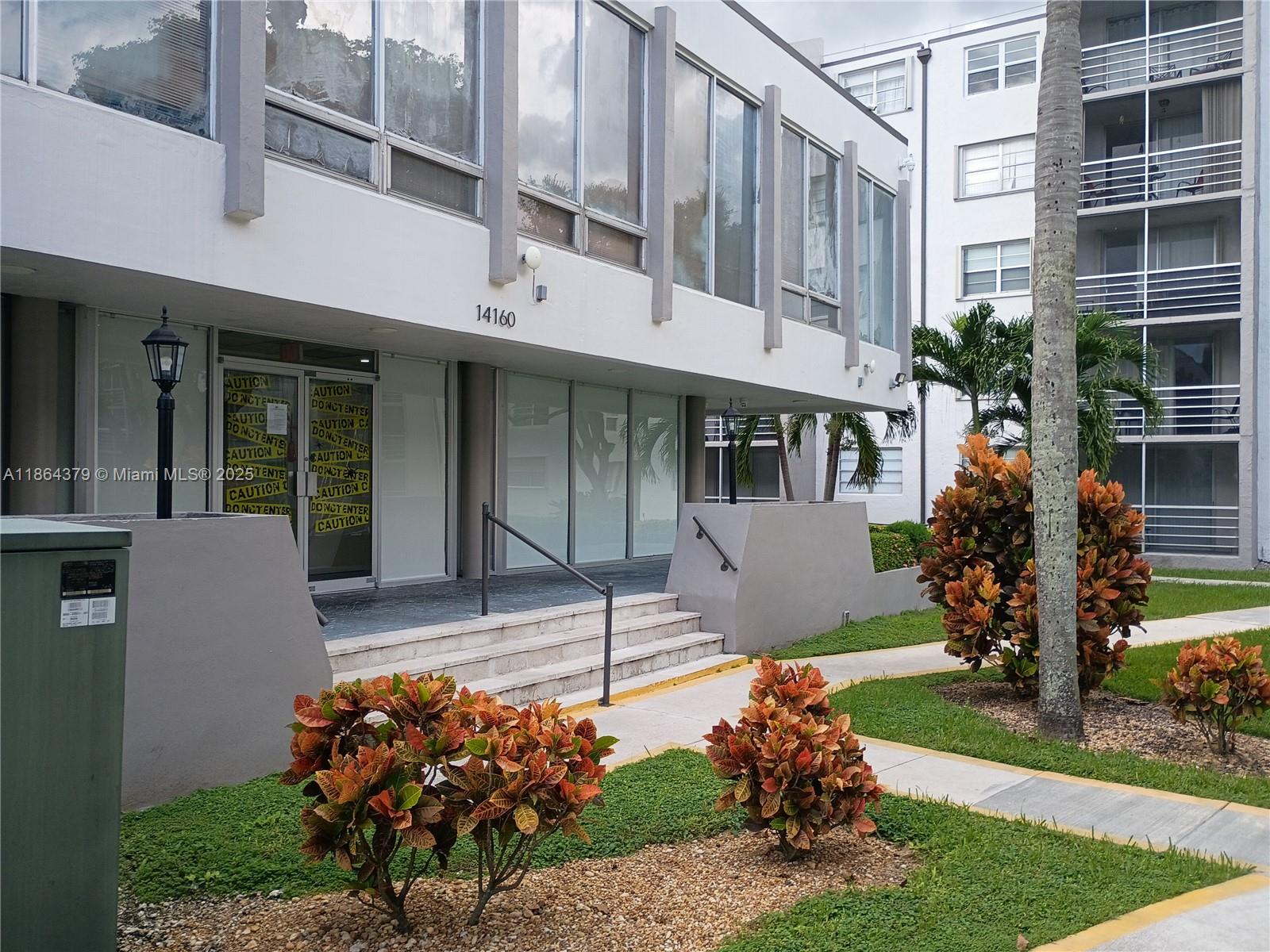 14165 Southwest 87th Street, Unit D103 Miami, FL 33183 - Photo 41 of 41 a front view of a building with a garden