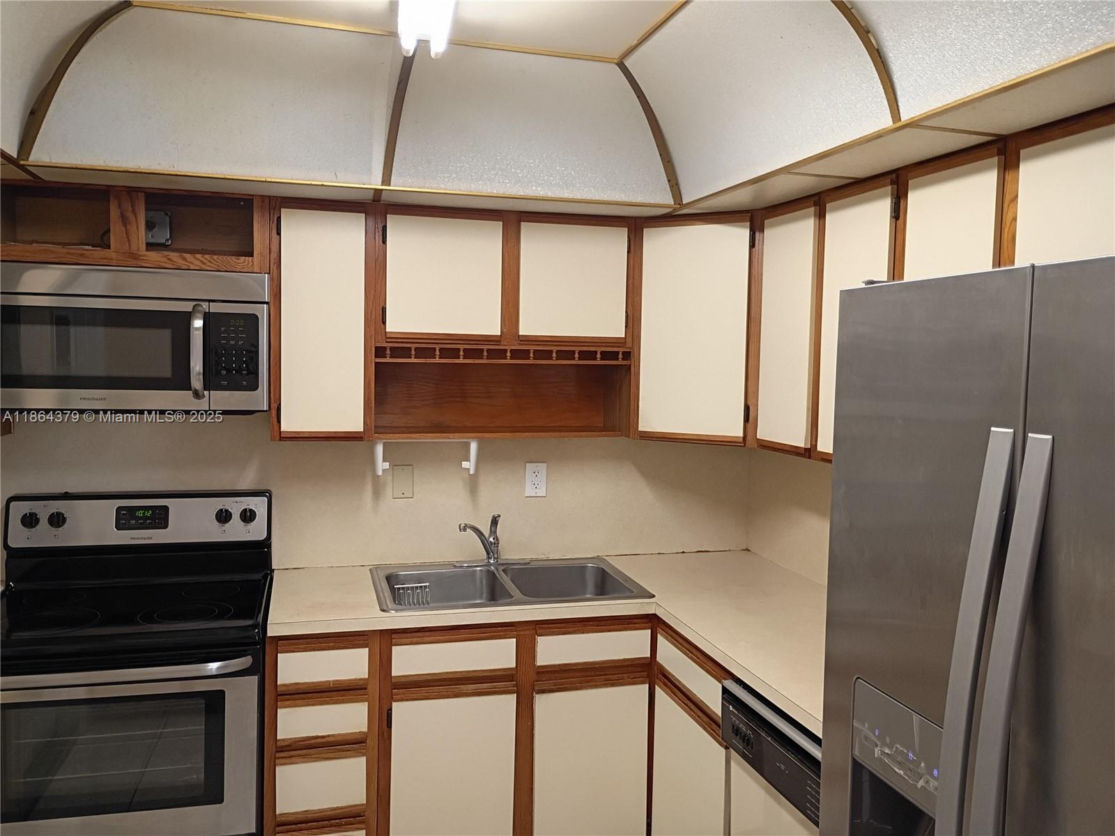 14165 Southwest 87th Street, Unit D103 Miami, FL 33183 - Photo 5 of 41 a kitchen with stainless steel appliances a sink and a refrigerator
