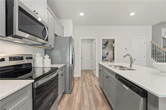 a kitchen with stainless steel appliances granite countertop a sink stove and refrigerator