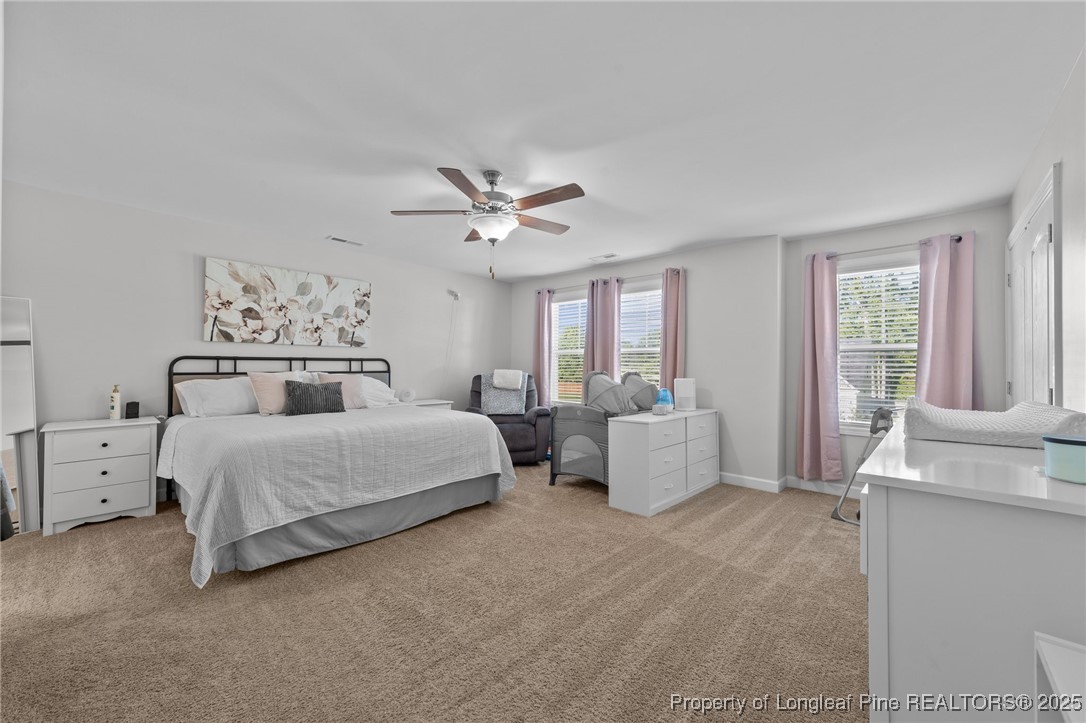 264 Mill Ridge Court Godwin, NC 28344 - Photo 18 of 43 a spacious bedroom with a bed and a chandelier