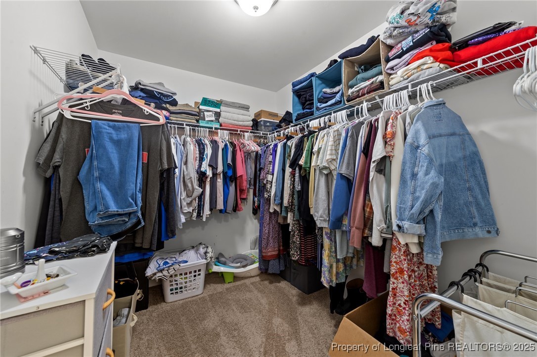 264 Mill Ridge Court Godwin, NC 28344 - Photo 22 of 43 a view of walk in closet with clothes and shoes