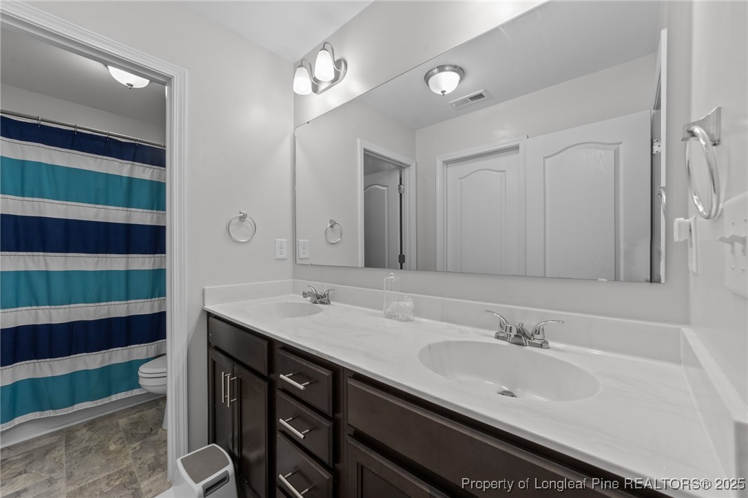 264 Mill Ridge Court Godwin, NC 28344 - Photo 28 of 43 a bathroom with a double vanity sink and mirror