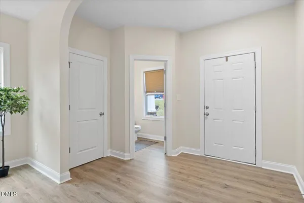 an empty room with wooden floor and closet area