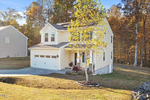 a view of a white house with a large tree
