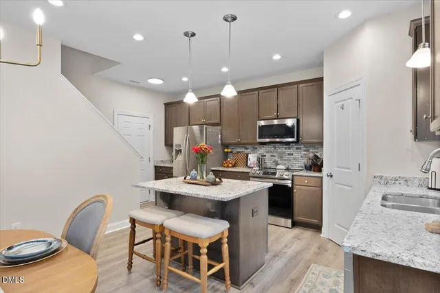 a kitchen with sink a microwave and chairs