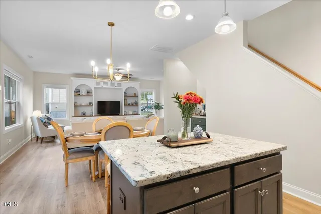 a dining room with kitchen island granite countertop furniture and a chandelier
