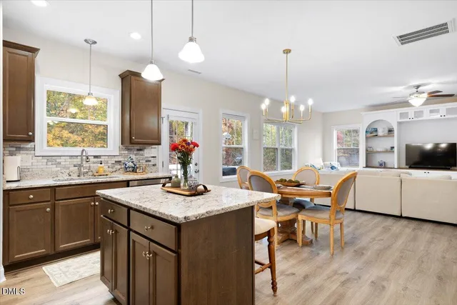 a kitchen with a kitchen island hardwood floor and a sink
