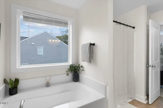 a bathroom with a tub shower and mirror