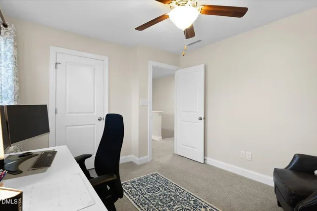 a view of a workspace with furniture and a window