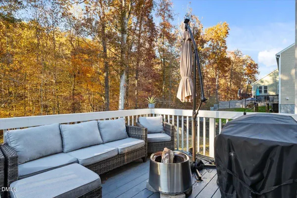 a roof deck with couches and wooden fence