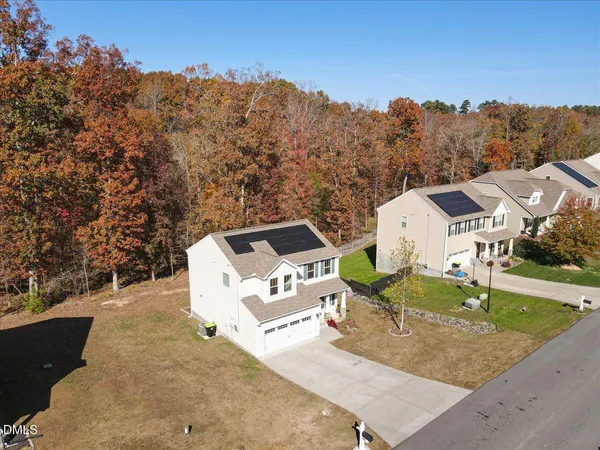 an aerial view of a house with a yard and wooden fence