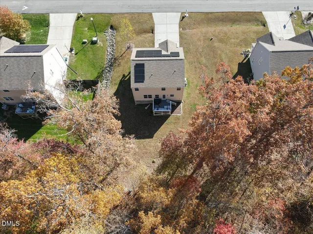a aerial view of a house with a yard and large tree