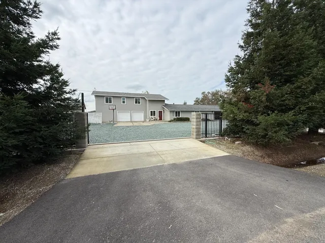 a view of an house with backyard and bushes