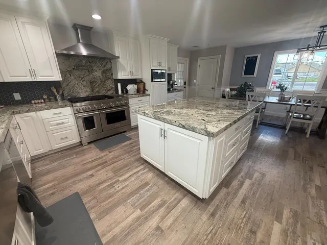 a kitchen with a stove and a wooden floor