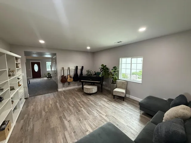 a living room with furniture and a wooden floor