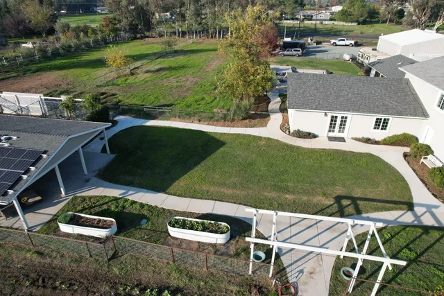aerial view of a house with garden space and patio