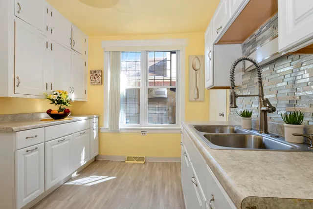 a kitchen with granite countertop a sink and white cabinets