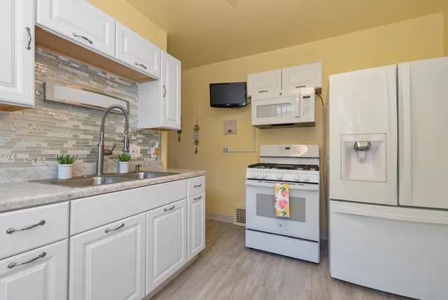 a kitchen with stainless steel appliances white cabinets and a refrigerator