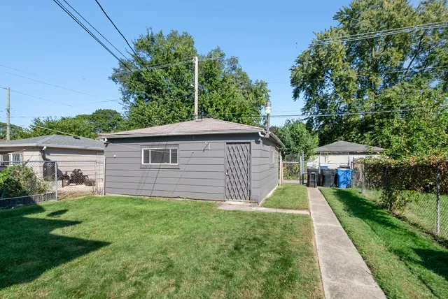 a view of a yard in front of a house with large tree