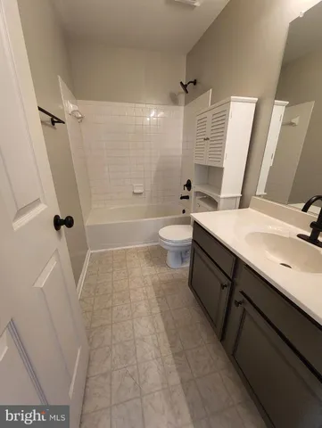 a bathroom with a sink a toilet a mirror and shower