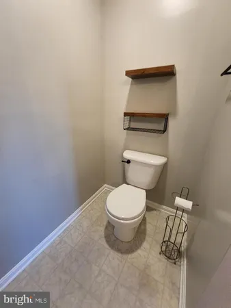 a white toilet sitting next to a white cabinet
