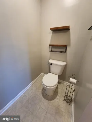 a white toilet sitting next to a white cabinet