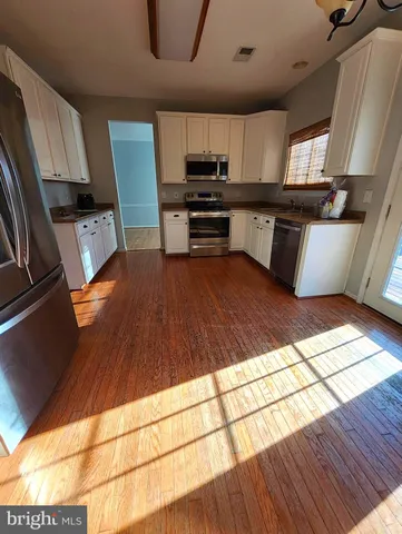 a kitchen with stainless steel appliances wooden cabinets and a stove top oven