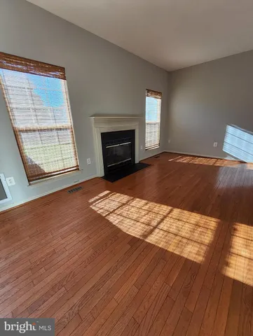 a view of empty room with wooden floor and fireplace