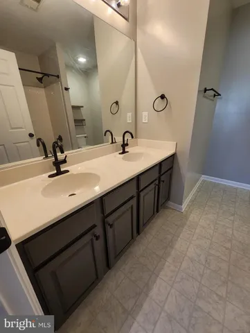 a bathroom with a double vanity sink a and mirror