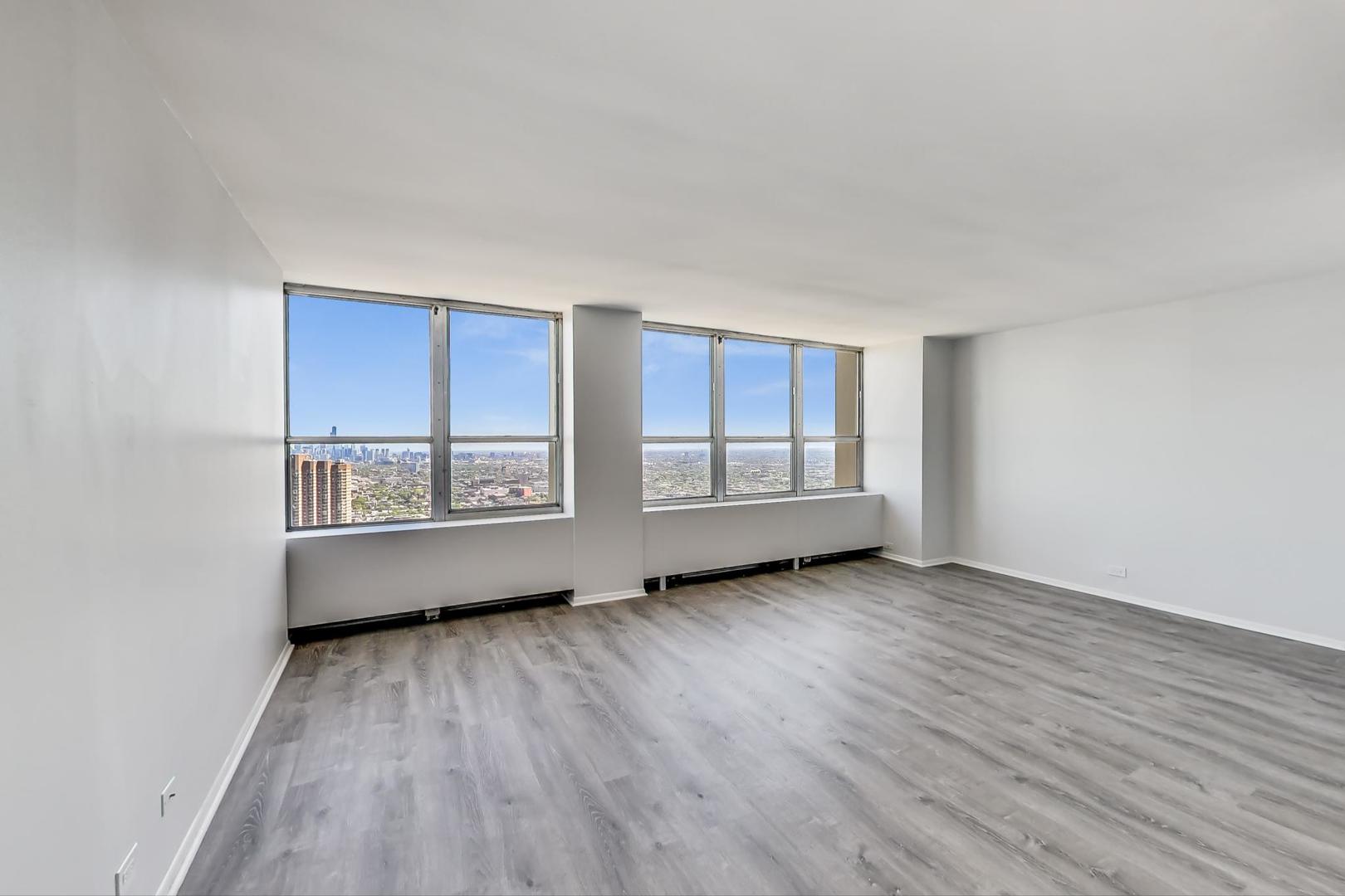 655 West Irving Park Road, Unit 5405 Chicago, IL 60613 - Photo 4 of 31 an empty room with wooden floor and windows