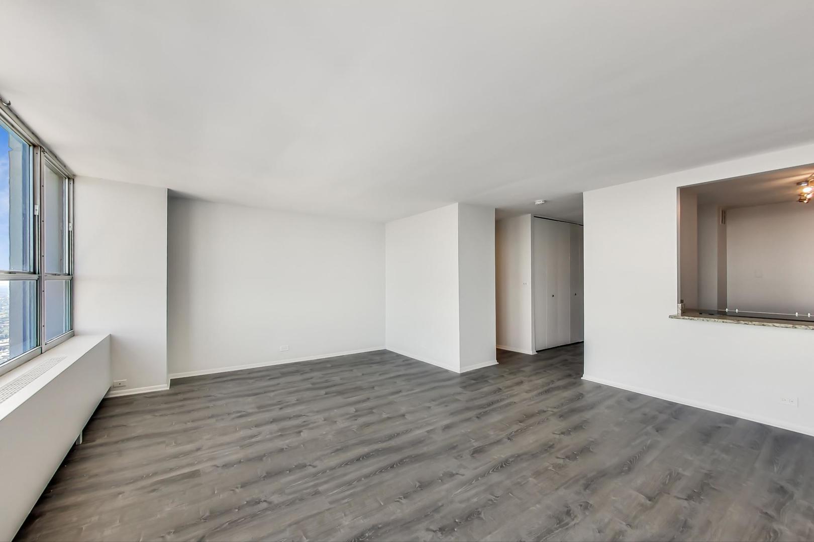 655 West Irving Park Road, Unit 5405 Chicago, IL 60613 - Photo 7 of 31 a view of an empty room with wooden floor and a window