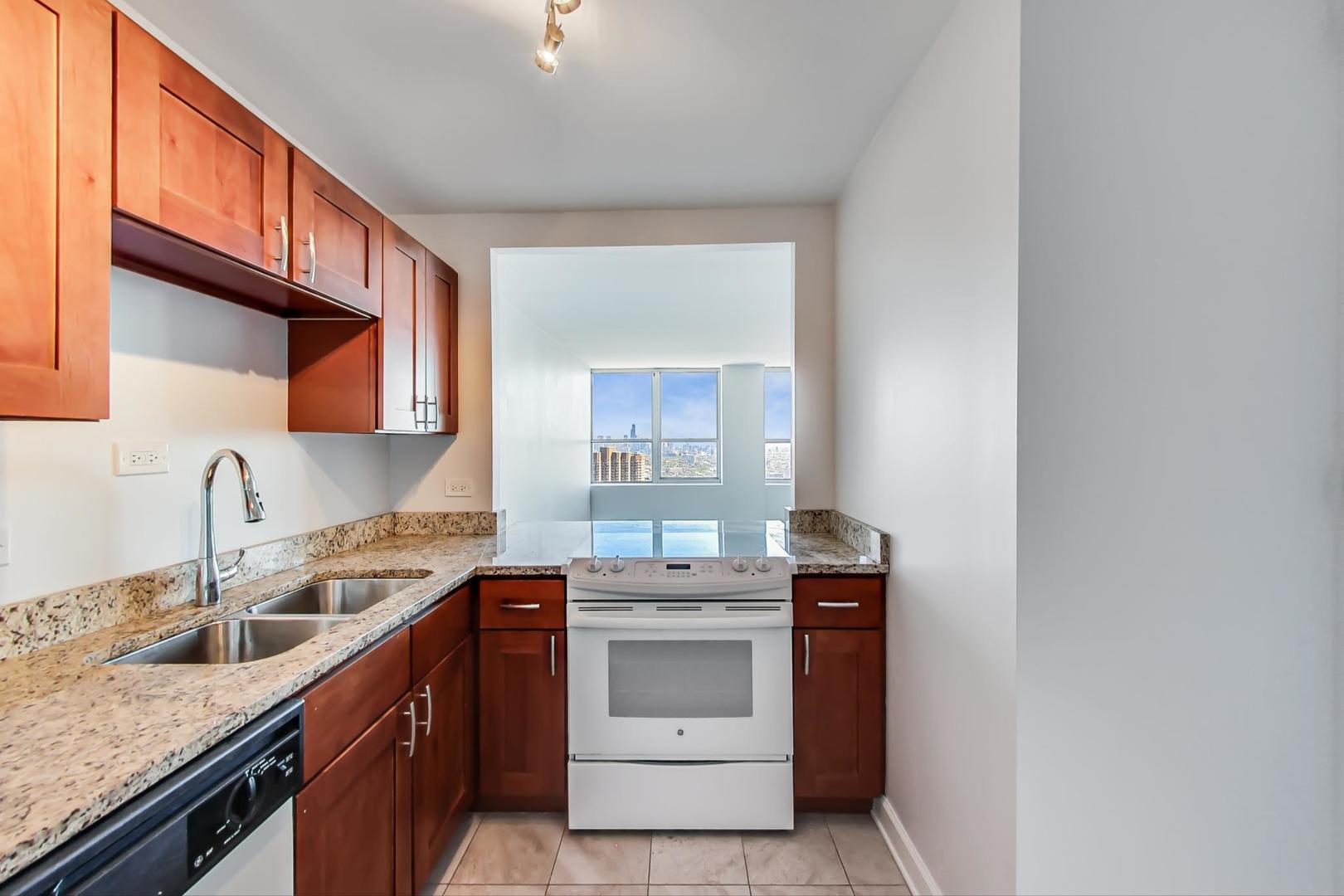 655 West Irving Park Road, Unit 5405 Chicago, IL 60613 - Photo 9 of 31 a kitchen with stainless steel appliances granite countertop a sink stove and cabinets
