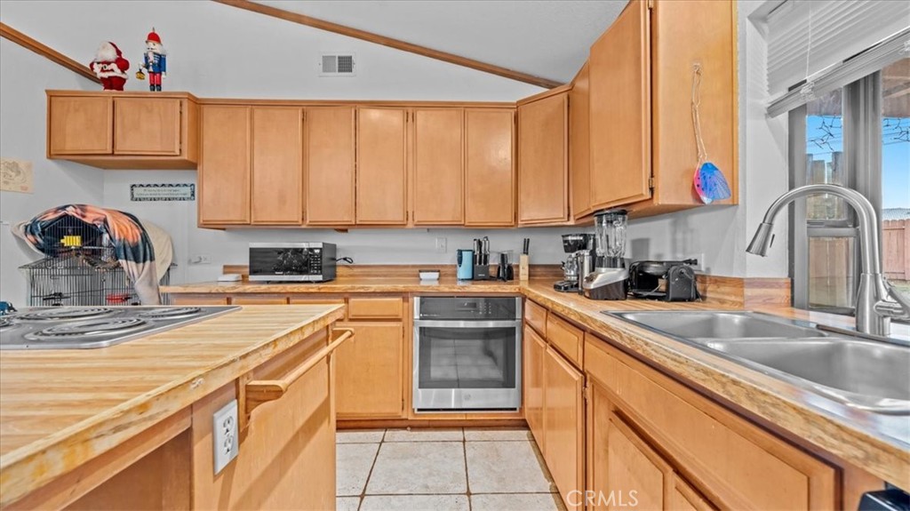 16043 St Timothy Road Apple Valley, CA 92307 - Photo 13 of 48 a kitchen with stainless steel appliances granite countertop a sink and cabinets
