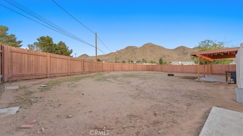 16043 St Timothy Road Apple Valley, CA 92307 - Photo 28 of 48 a view of a backyard with a large tree