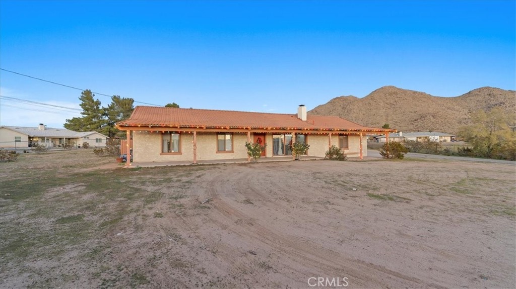 16043 St Timothy Road Apple Valley, CA 92307 - Photo 5 of 48 a view of a large house with a mountain yard