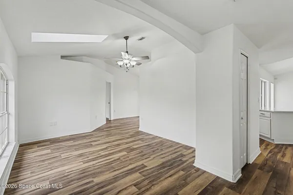 a view of a room with wooden floor and ceiling fan