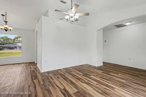 wooden floor in an empty room with a chandelier
