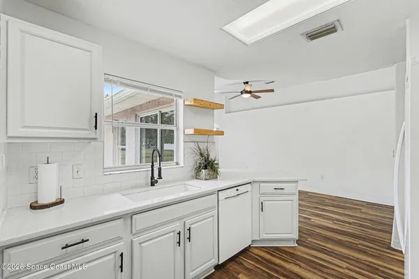 a view of a livingroom with wooden floor and a ceiling fan