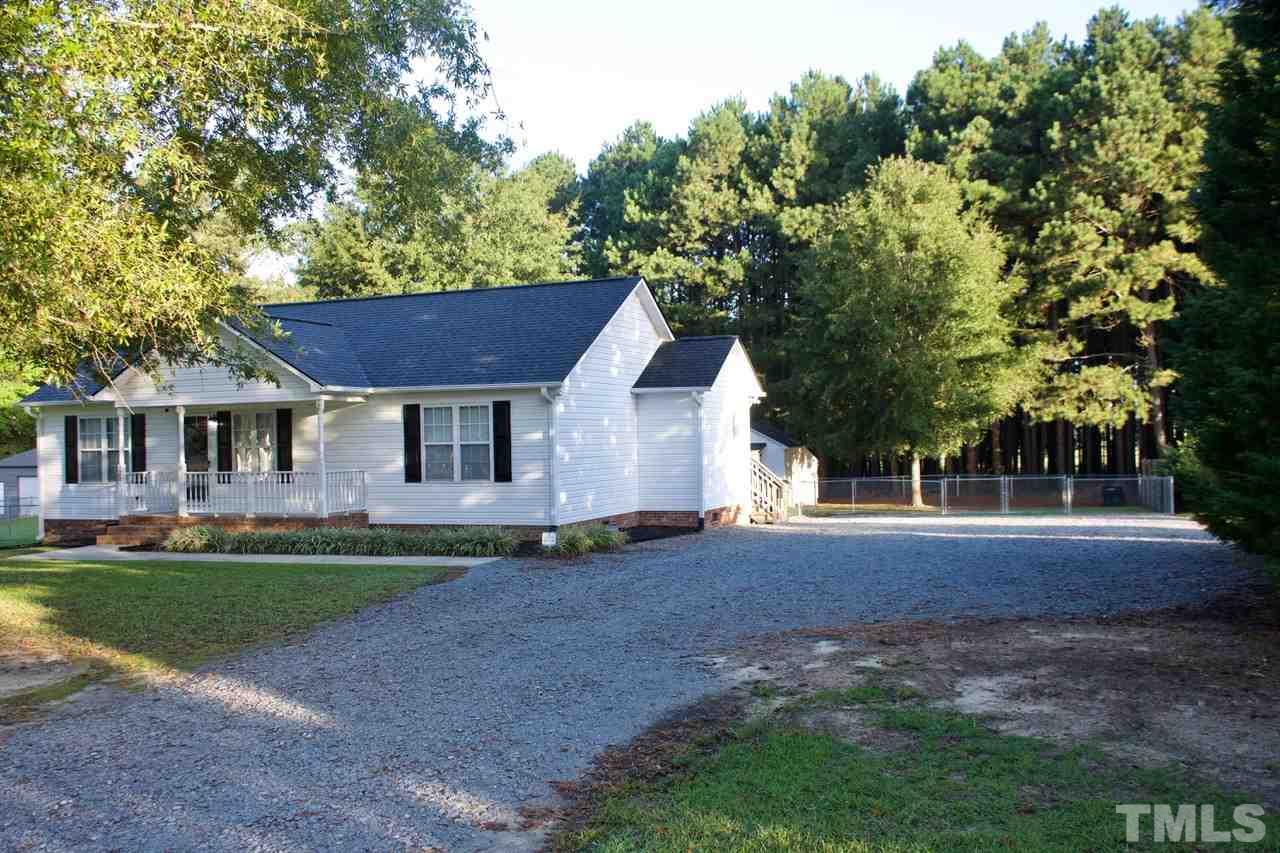 128 Forest Ridge Drive Willow Spring, NC 27592 - Photo 2 of 25 a front view of a house with a garden and trees