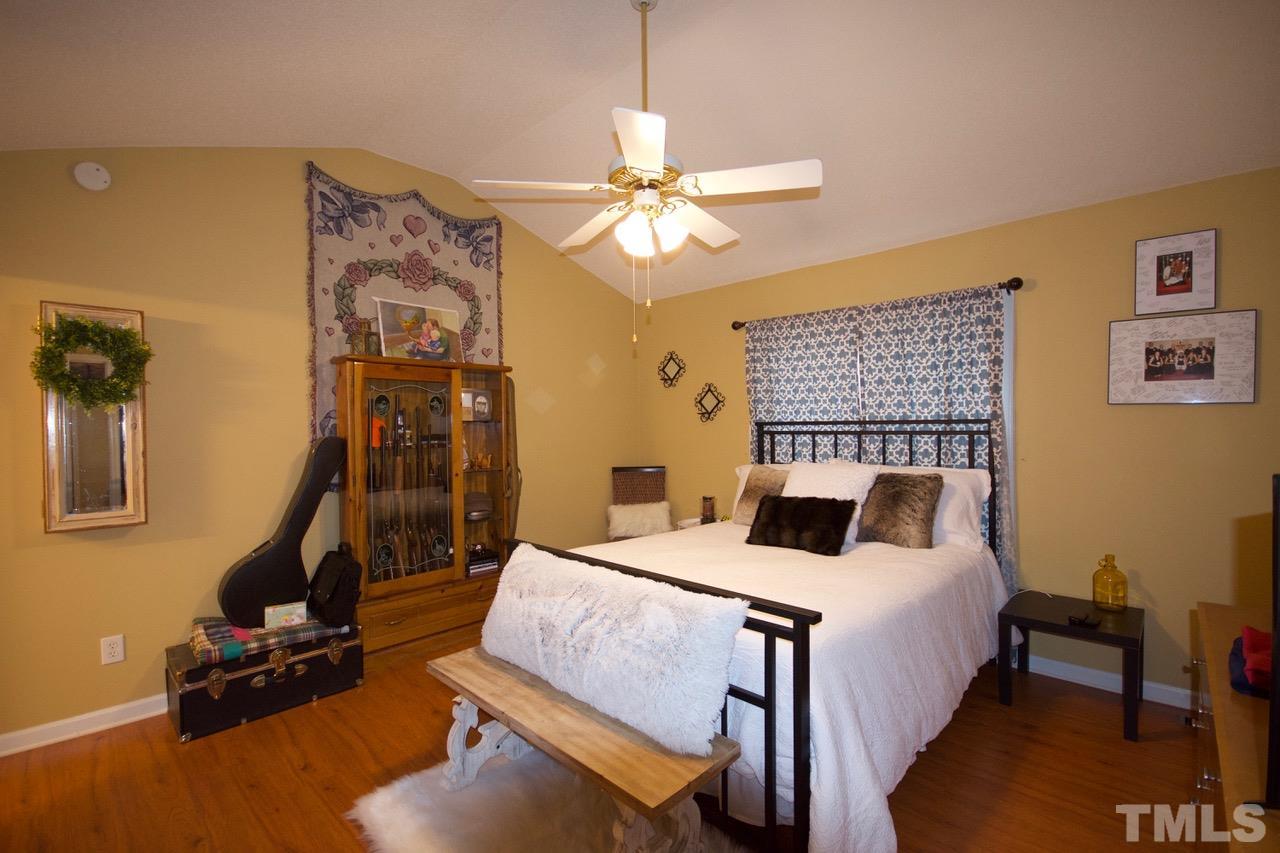 128 Forest Ridge Drive Willow Spring, NC 27592 - Photo 11 of 25 a bedroom with a bed and a chandelier