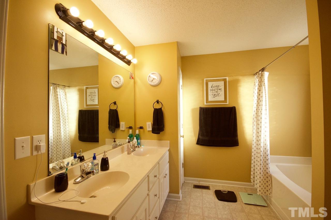 128 Forest Ridge Drive Willow Spring, NC 27592 - Photo 13 of 25 a bathroom with a tub sink and mirror