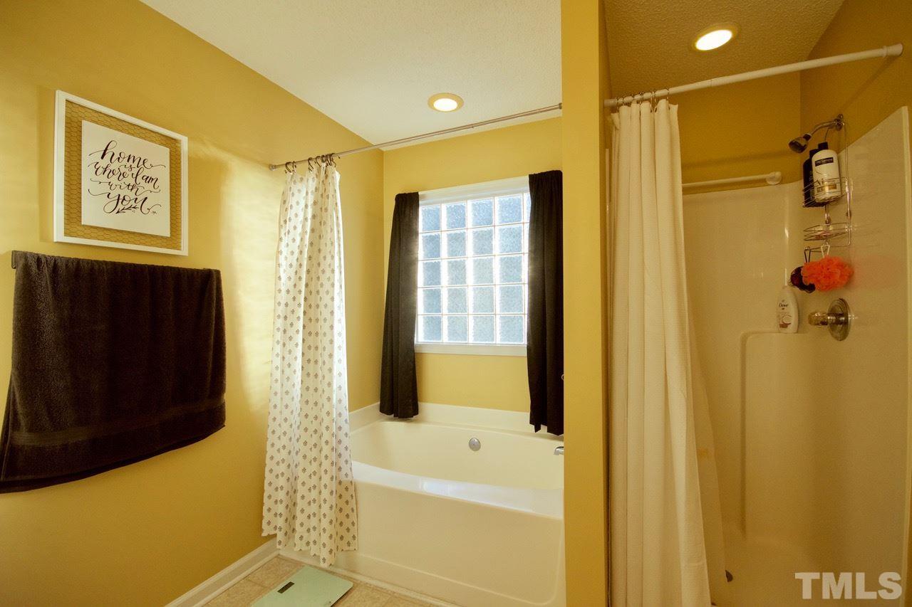 128 Forest Ridge Drive Willow Spring, NC 27592 - Photo 15 of 25 a bathroom with a bathtub shower and a sink