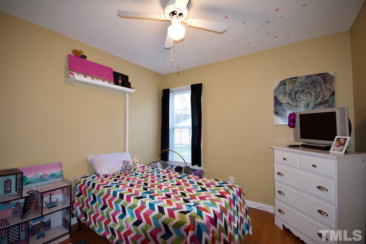 128 Forest Ridge Drive Willow Spring, NC 27592 - Photo 16 of 25 a bedroom with a bed and a flat screen tv