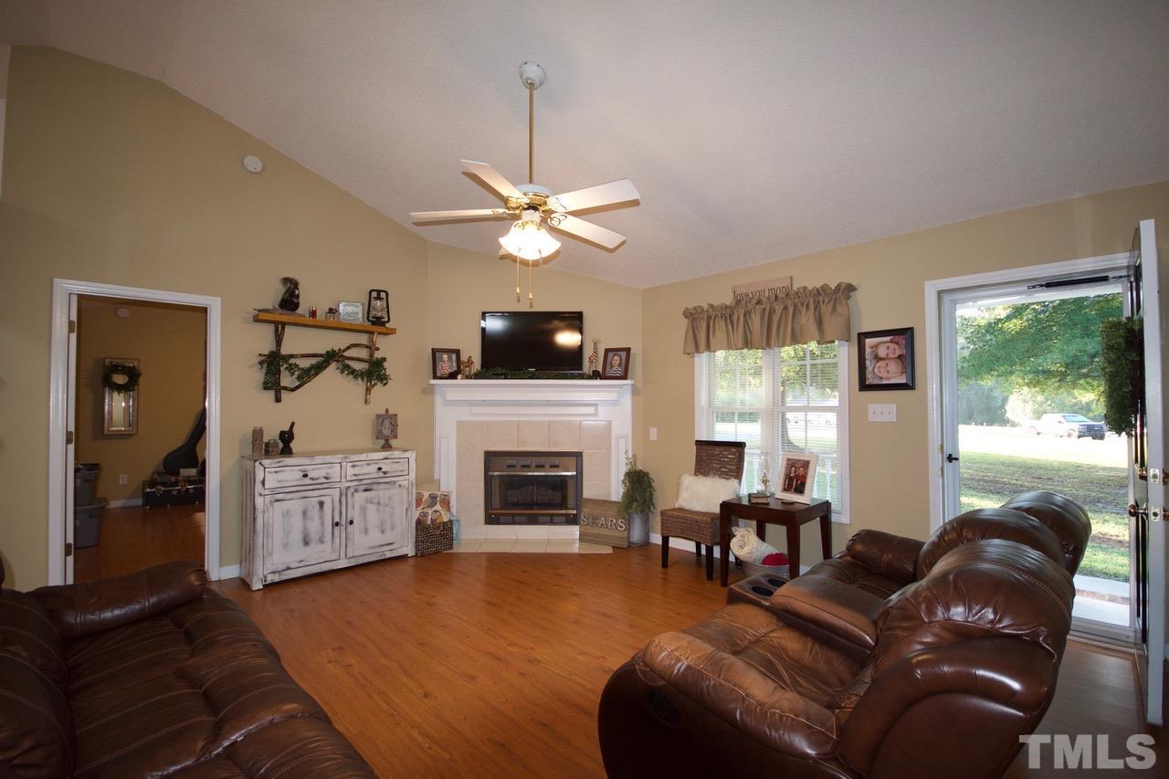 128 Forest Ridge Drive Willow Spring, NC 27592 - Photo 3 of 25 a living room with furniture fireplace and a flat screen tv