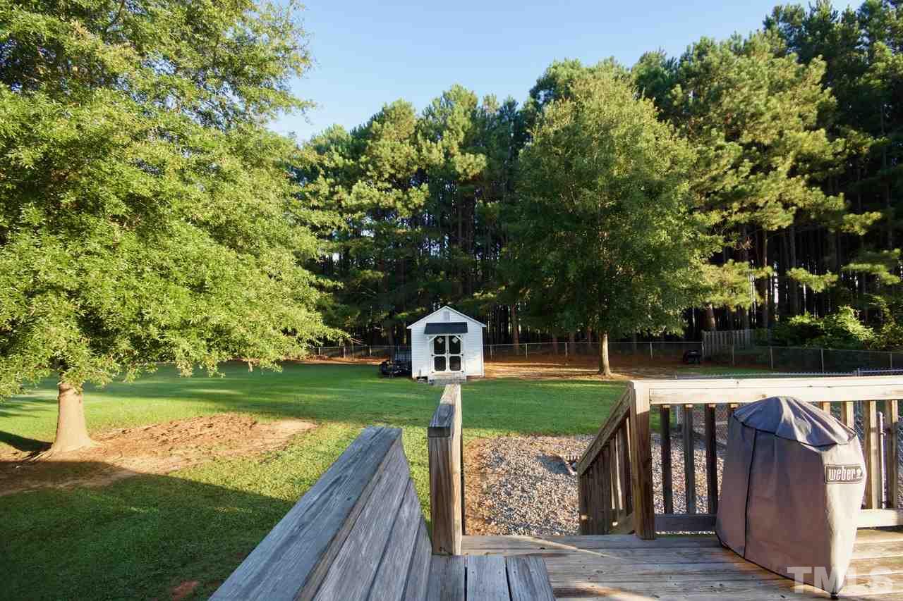 128 Forest Ridge Drive Willow Spring, NC 27592 - Photo 21 of 25 a view of a wooden deck and a yard