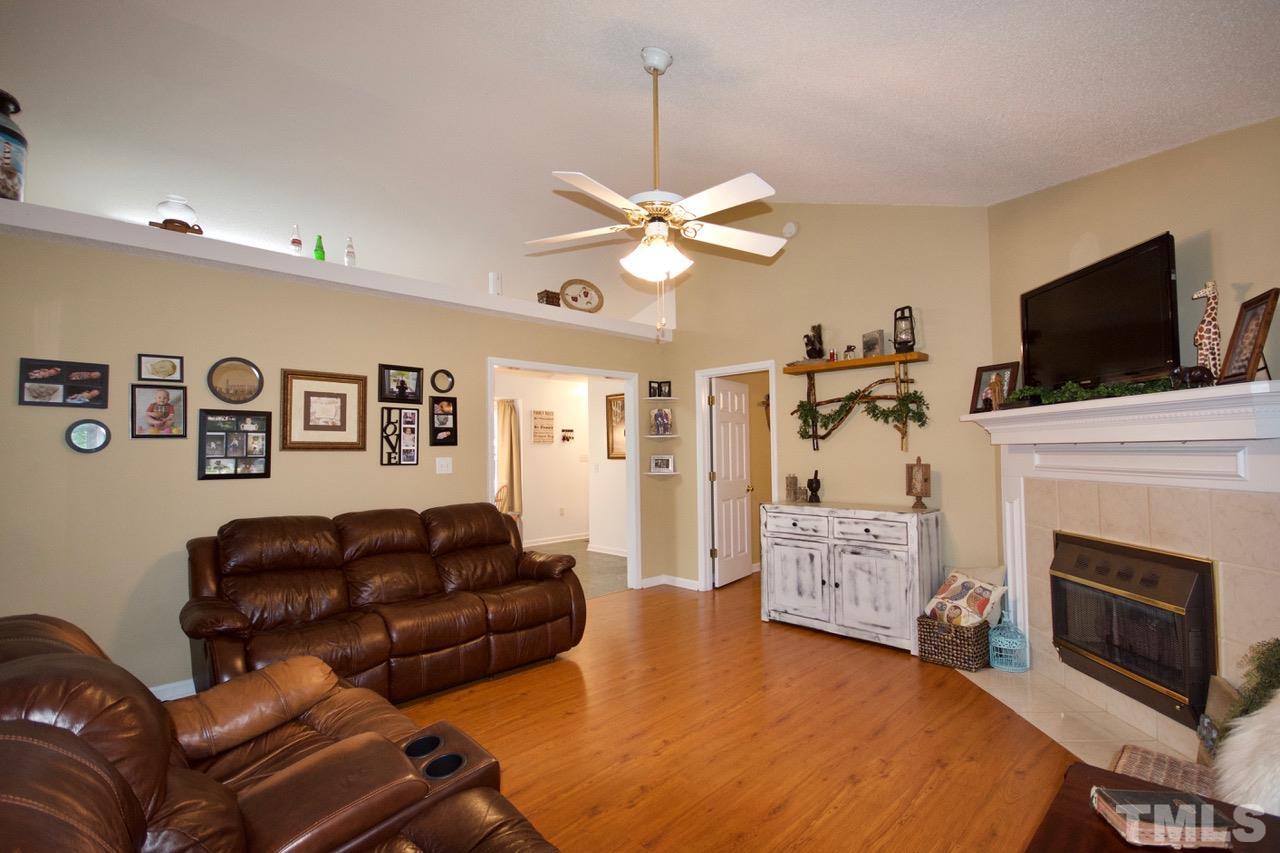 128 Forest Ridge Drive Willow Spring, NC 27592 - Photo 4 of 25 a living room with furniture a fireplace and a flat screen tv